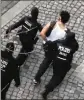  ?? AP ?? A suspect in a potential attack is led away by police officers after he was arrested in Berlin on Sunday.