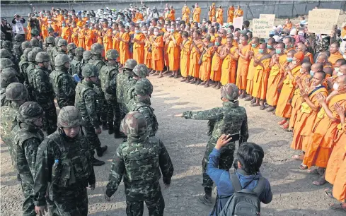  ?? CHAROENKIA­TPAKUL WICHAN ?? A photo taken on Thursday shows military officers and Wat Phra Dhammakaya monks in a stand-off as officials prepare to conduct a search for former abbot Phra Dhammajayo.