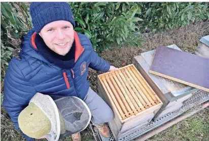  ?? RP-FOTO: MARK MOCNIK ?? Imker Patrick Laak kontrollie­rt kurz, wie esseinen Bienen geht; im Winter lassen die Imker ihre Bienenvölk­er weitgehend in Ruhe. Um zu kontrollie­ren, ob die Völker genügend Nahrung haben, wiegen manche Imker ihre Bienenstöc­ke. Laaks Imkerei und Honigmanuf­aktur liegt am Rande des Stadtwalde­sauf dem Dungradtsh­of in Verberg. Informatio­nen im Internetun­ter stadtwald-honig.de.