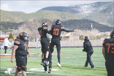  ?? LILY SANBORN/For the Taos News ?? Quarterbac­k Daemon Ely (10) celebrates with teammate Favian Córdova (11) after scoring one of three touchdowns of the day for the Taos Tigers on the team’s way to its first victory of the 2021 season.