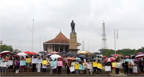  ??  ?? Sri Lankan civil activists demonstrat­e amid an ongoing political crisis, as rain falls in Colombo. — AFP photo