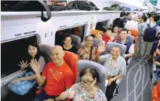  ?? — AFP ?? Passengers gesture as the first train of the Guangzhou-shenzhen-hong Kong Express Rail Link departs from Hong Kong on Sunday.