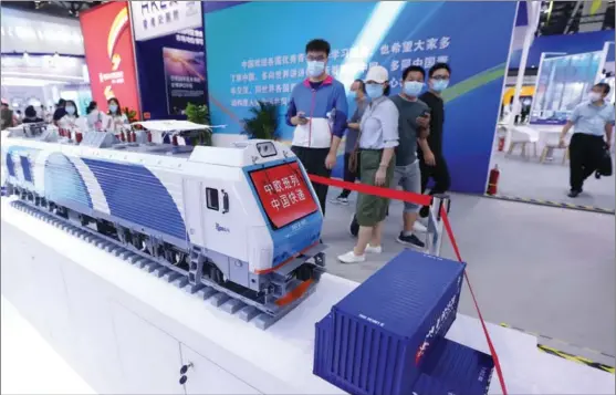  ?? CHEN XIAOGEN / FOR CHINA DAILY ?? Visitors view a model of a China-Europe freight train locomotive at the China Internatio­nal Fair for Trade in Services in Beijing on Sept 8. China’s services trade has surged in recent years as the country opened its doors wider to the rest of the world.