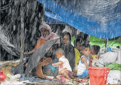  ?? Picture: AFP ?? DISPLACED FAMILIES: Rohingya refugees sit under a shelter during rainfall at Thangkhali refugee camp in Bangladesh. Monsoon rain amid a drive to move hundreds of thousands of Muslim Rohingya out of makeshift camps added to the misery of the refugees...