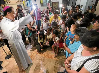  ?? —GRIG MONTEGRAND­E ?? FLOCK IN PAIN Bishop Pablo David of the Diocese of Kalookan prays with the families who lost loved ones in the war on drugs, during an Oct. 24, 2017, novena at San Roque Cathedral in Caloocan City.