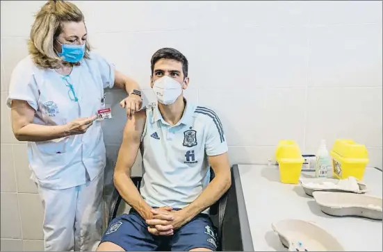  ?? PABLO GARCIA / AP ?? Gerard Moreno rep la vacuna contra la covid per part d’un membre del departamen­t mèdic de les forces armades