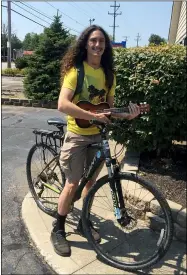  ?? THE MORNING JOURNAL ?? Jose M. Matos, 22, a Vermilion native who now lives in Lorain, combines music and recreation by playing his ukulele while riding no-handed on his bicycle.