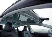  ??  ?? PRACTICALI­TY There’s plenty of space in the Model 3 and the panoramic sunroof gives an airy feel to overcome the dark cabin materials