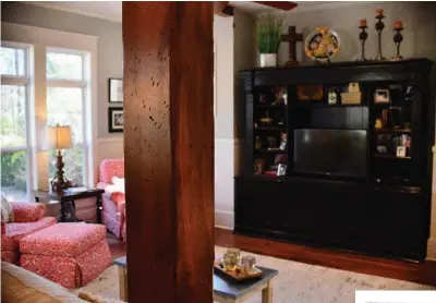  ??  ?? From left: A small powder room, featuring a mirror Rik Sowell made from salvaged barn material, has a door that leads to his backyard. A rustic column separates the kitchen from the living room, which has chairs situated in front of windows for a...