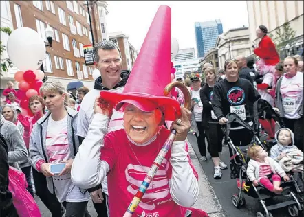  ??  ?? Karee celebrates by using one of the cones marking the finish line as a kooky pink chapeau. A breast-cancer survivor, she has been attending the Race for the Cure since 2000.