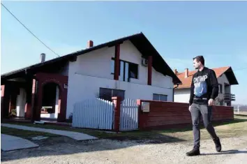  ?? — AFP ?? A man walks by a family house where a body was found in a freezer in the village of Palovec in northern Croatia.