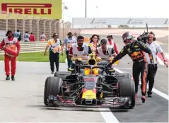  ?? JUN QIAN/JAWA POS ?? TIDAK OPTIMAL: Max Verstappen ikut mendorong mobilnya yang mogok pada lap ketiga sesi latihan bebas pertama GP Bahrain di Bahrain Internatio­nal Circuit, Sakhir, kemarin.