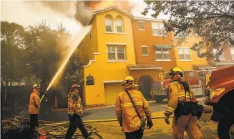  ?? Gabrielle Lurie / The Chronicle 2017 ?? Firefighte­rs work to contain the Tubbs Fire at the Overlook apartment complex in Santa Rosa.