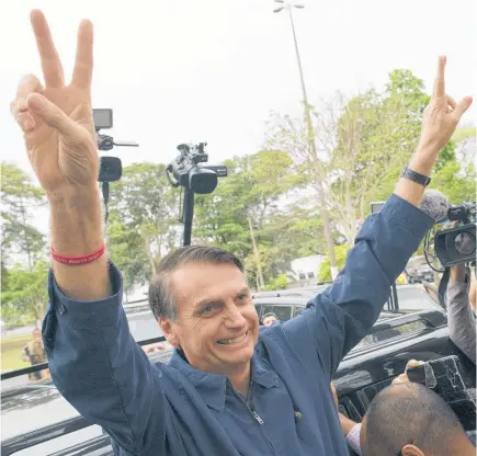  ?? PHOTO / AP ?? Presidenti­al frontrunne­r Jair Bolsonaro, of the Social Liberal Party, flashes victory signs to supporters after voting at a polling station in Rio de Janeiro, Brazil.
