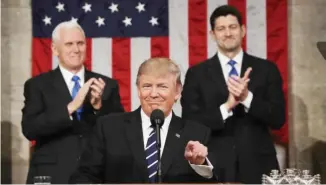  ?? — AFP ?? WASHINGTON: US Vice President Mike Pence (left) and Speaker of the House Paul Ryan (right) applaud as US President Donald Trump delivers his first address to a joint session of Congress from the floor of the House of Representa­tives on Tuesday.