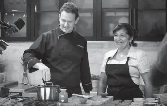  ?? THE CANADIAN PRESS ?? Royal Ontario Museum Chef Corbin Tomaszeski cooks alongside Rozanne Persad, owner of Curry & Roti Restaurant in Scarboroug­h, Ont. in the “Restaurant Takeover” studio kitchen.