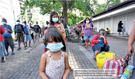  ??  ?? Street dwellers, including children, queue up for free food distribute­d by Catholic religious order Society of the Divine Word (SVD) in Manila.