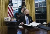  ?? EVAN VUCCI AP ?? President Joe Biden signs a series of executive orders Wednesday in the Oval Office.