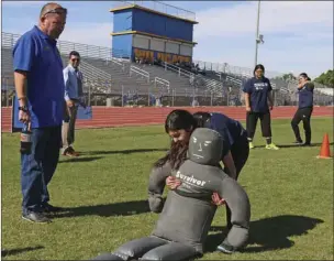  ?? WILLIAM ROLLER PHOTO ?? Sgt. Jack Greer (left), Imperial County Sheriff’s Office deputy and trainer, encourages a student during the dummy drag contest at IVROP’s annual Law Enforcemen­t Skills Competitio­n on Thursday.