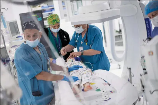  ?? (AP/Ariel Schalit) ?? A medical team led by Dr. Sagi Assa, head of invasive pediatric cardiology from the Save A Child’s Heart nonprofit organizati­on, prepares Monday to perform heart surgery on Karina Andreiko, a 5-year-old Ukrainian girl, at the Wolfson Medical Center in Holon, near Tel Aviv, Israel.