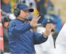  ?? THE ASSOCIATED PRESS ?? West Virginia football coach Dana Holgorsen signals to his players at a home game against Texas last season. The Mountainee­rs will take on Tennessee to open the season Saturday in Charlotte, N.C.