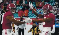  ?? CHRIS O’MEARA — THE ASSOCIATED PRESS ?? Alabama wide receiver John Metchie III, left, congratula­tes wide receiver DeVonta Smith, after Smith scored a touchdown against Ohio State during the first half of the national championsh­ip game Monday.