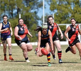  ??  ?? BREATHING DOWN HER NECK: University player Felicity Ash gathers a loose ball with a horde of South Toowoomba players in chase.