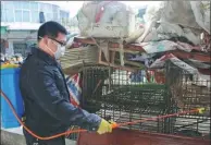  ?? LI JIANPING / FOR CHINA DAILY ?? A worker disinfects poultry cages at a market in Suichuan county, Jiangxi province, on Sunday. The county has ordered the closure of local poultry markets from Saturday to March 10.