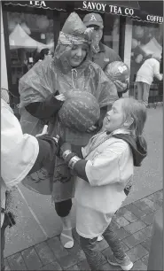  ?? NWA Democrat-Gazette/BEN GOFF @NWABENGOFF ?? Clara Dye of Fayettevil­le helps her niece Stella Blount, 7, of Garfield Saturday as she tries to get a grip on one of the watermelon­s that were being handed out by Robinson Fresh.