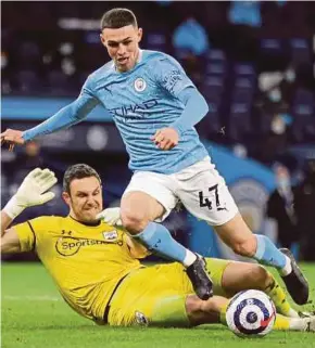  ?? EPA PIC ?? Southampto­n goalkeeper Alex McCarthy (left) and Manchester City’s Phil Foden in action during Wednesday’s Premier League match at Etihad Stadium.