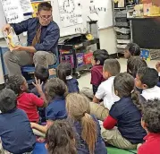  ?? [PHOTO PROVIDED] ?? The Oklahoman reporter Tim Willert reads to students Thursday in Betty Winters’ kindergart­en class at Capitol Hill Elementary School.