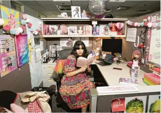  ?? MAANSI SRIVASTAVA / THE NEW YORK TIMES ?? Jolena Podolsky in her cubicle at Simon & Schuster offices in Manhattan on Aug. 21. Once derided as symbols of a commodifie­d work force, cubicles are making a comeback, and workers are personaliz­ing them and posting photos on social media.