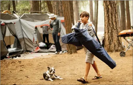  ?? THE ASSOCIATED PRESS FILE ?? River Martinez, 10, breaks camp at the Upper Pines Campground in Yosemite National Park. The Interior Department is considerin­g recommenda­tions to modernize campground­s at national parks, adding running water, food trucks, Wi-fi and more, and allowing the private sector to run the sites.