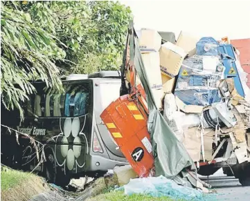 ??  ?? DEADLY ACCIDENT: The lorry and express bus after the collision. — Bernama photo