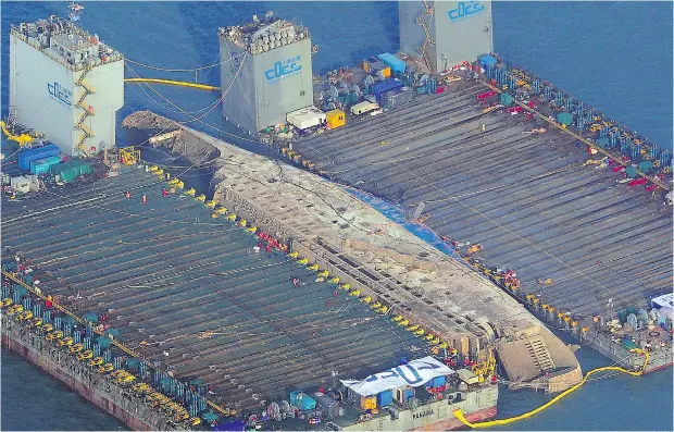  ?? AFP/ GETTY IMAGES ?? The damaged Sewol ferry is shown between two barges after being raised during a salvage operation off the South Korean coast on Thursday. It’s been nearly three years since the Sewol went down with the loss of more than 300 lives, mostly students on a...