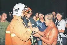  ??  ?? Nuang (right) speaks to firefighte­rs.