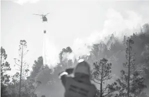  ?? — Gambar AFP ?? PEMBAKARAN DENGAN SENGAJA: Gambar serahan Taman Negara Argentina menerusi Telam menunjukka­n helikopter mencurahka­n air untuk memadamkan kebakaran di Taman Negara Los Alerces di wilayah Chubut pada Jumaat lepas.