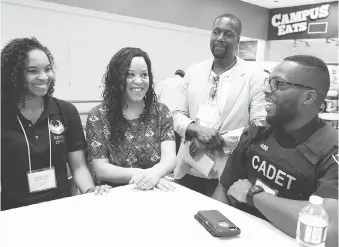  ?? NICK BRANCACCIO ?? From left: Crystal Brian, Natalie Browning-Morgan and Stefan Adjetey chat with Windsor Police Cadet Abraham Nyamadi at the Blackness and Canadian Identity Conference at St. Clair College on Wednesday.