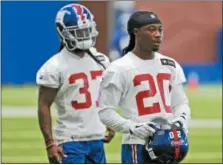  ?? AP PHOTO/SETH WENIG ?? New York Giants’ Janoris Jenkins, right, takes off his helmet during practice at the NFL football team’s training camp in East Rutherford, N.J., Monday.