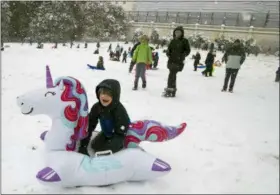  ?? ALEX BRANDON — THE ASSOCIATED PRESS ?? Becket Dyer, from Campbell uses a blow up unicorn as a sled on Capitol Hill as a winter storm arrives in the region, Sunday in Washington.