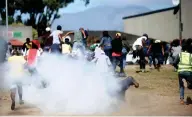  ?? | AYANDA NDAMANE African News Agency (ANA) ?? POLICE throw stun grenades to disperse protesting students outside the Western Cape Nursing College in Athlone yesterday.