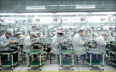  ?? PROVIDED TO CHINA DAILY ?? Employees of Foxconn Technology Group work at a production line of the company in Zhengzhou, capital of Henan province.