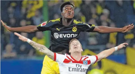  ?? FOTO: AFP ?? Starke Haltungsno­ten: BVB-Verteidige­r Dan-Axel Zagadou (oben) und Andre Hahn fliegen über den Platz.