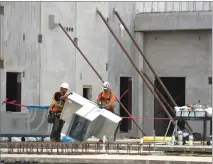  ??  ?? Constructi­on workers stay busy Thursday on the east side of the South County Detention Facility.