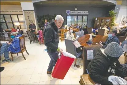  ??  ?? Gallery Furniture store owner Jim McIngvale collects trash inside the business.