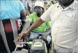  ?? PHOTOS: SANDILE NDLOVU ?? Wheelchair-bound Nhlanhla Zungu is assisted by a Sassa employee before collecting his grant.
