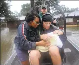  ?? JOE RAEDLE/GETTY IMAGES ?? Shardea Harrison watches Dean Mize hold her 3-week-old baby, Sarai Harrison, during evacuation.