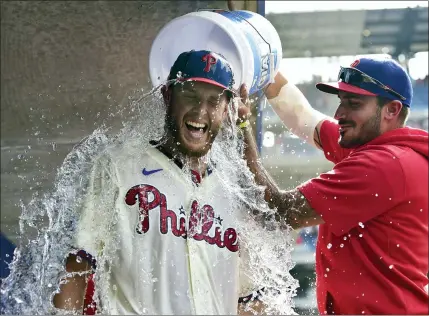  ?? DERIK HAMILTON - THE ASSOCIATED PRESS ?? Philadelph­ia Phillies starting pitcher Zack Wheeler is doused with water in the dugout by teammates Zack Eflin, right, and Aaron Nola, rear, after a victory against the New York Mets, Sunday, in Philadelph­ia. The Phillies won 3-0.