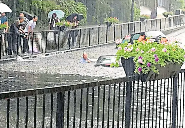  ??  ?? Cars submerged in Wallington, south London, yesterday, after the area was hit with a month’s worth of rainfall in just one hour. Flash flooding was caused by warm, moist air from the Continent, forecaster­s said