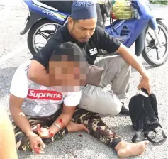  ??  ?? The suspect (front), who was caught red-handed stealing a wallet from a hawker, ends up with injuries after the citizens’ arrest.